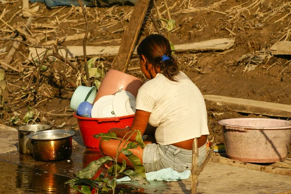 Donna che lava i piatti sulle rive del fiume — Foto Stock