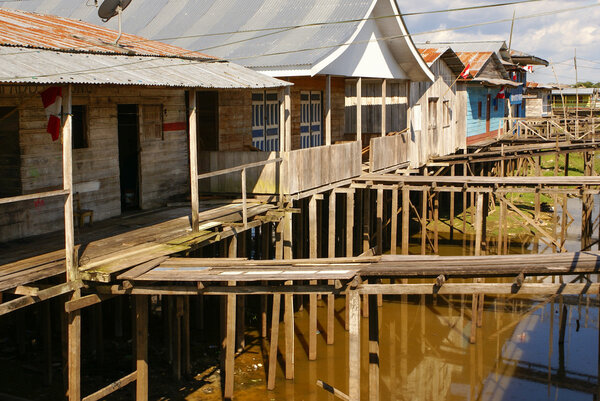 Houses on stilts rise above the polluted water in Islandia Peru