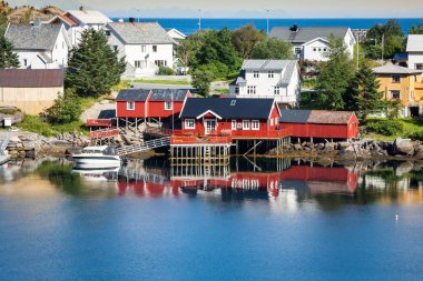 Geleneksel kırmızı rorbu kulübesi olan tipik Norveç balıkçı köyü.