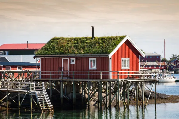 Geleneksel kırmızı rorbu kulübesi olan tipik Norveç balıkçı köyü. — Stok fotoğraf