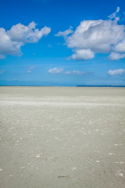 Oceaan bij laag tij onder blauw bewolkte hemel, bij mont saint michelle — Stockfoto