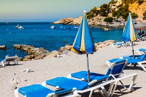 Sedie a sdraio sulla sabbia in una spiaggia idilliaca di Ibiza, Baleari — Foto Stock