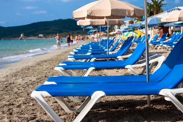 Chaises longues sur le sable dans une plage idyllique à Ibiza, Baléares — Photo