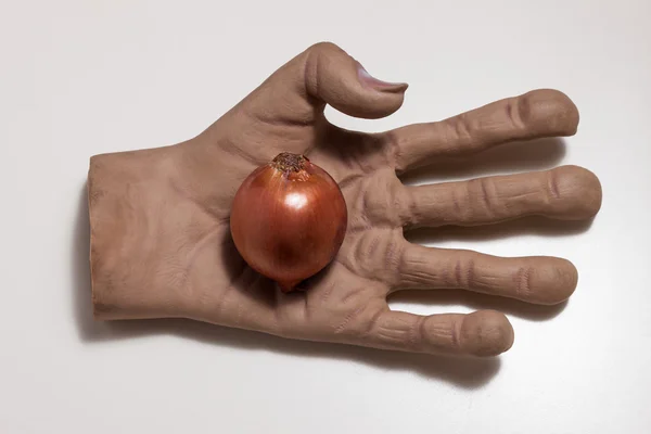 Huge hand holding an onion — Stock Photo, Image