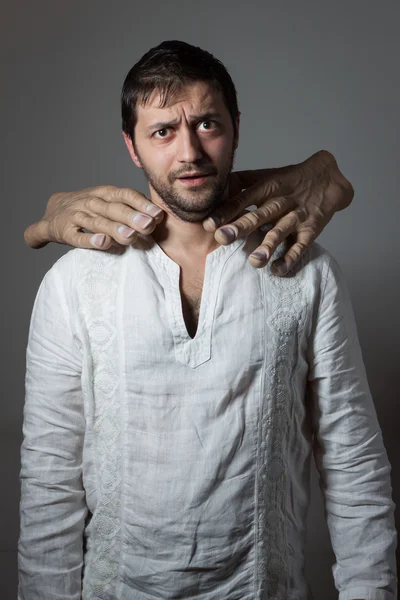 Junger bärtiger Mann von zwei riesigen Händen erstickt — Stockfoto