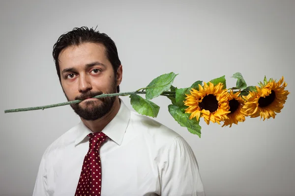 Porträt eines jungen bärtigen Mannes mit Sonnenblumen — Stockfoto