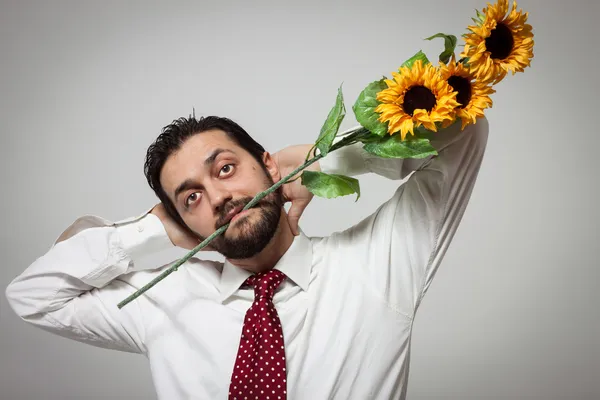 Porträt eines jungen bärtigen Mannes mit Sonnenblumen — Stockfoto