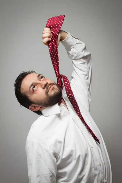 Jonge, bebaarde man doen alsof ze hangen zichzelf met een stropdas — Stockfoto