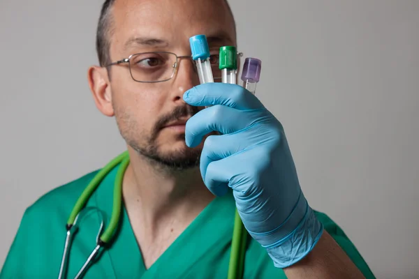 Portrait of a young physician looking at test tubes — Stock Photo, Image