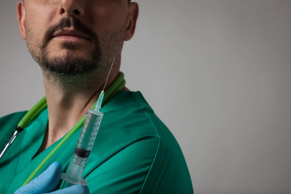 Retrato de un joven médico sosteniendo la jeringa — Foto de Stock