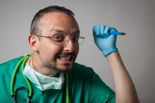 Divertido doctor loco sosteniendo un cuchillo quirúrgico — Foto de Stock