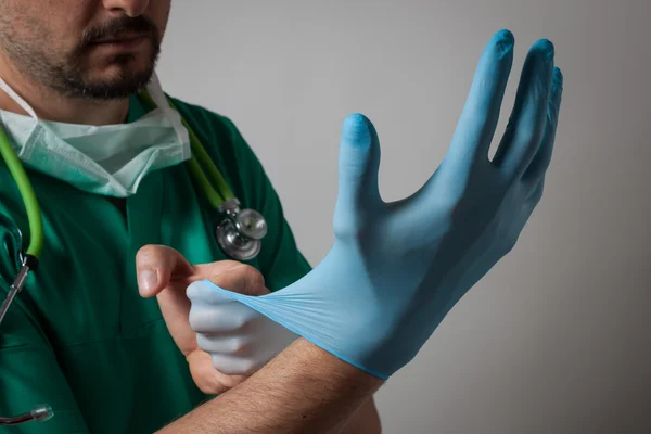 Doctor poniéndose un guante — Foto de Stock