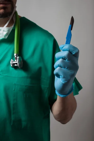 Médico sosteniendo un cuchillo quirúrgico — Foto de Stock