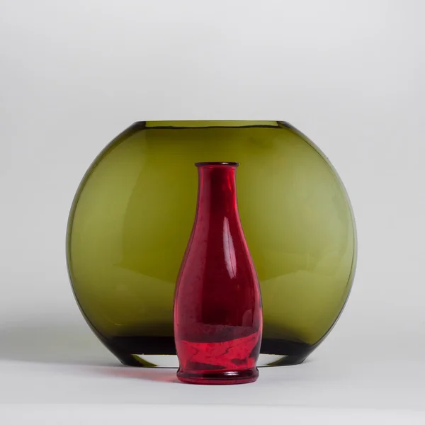 Still life of red bottle and green vase — Stock Photo, Image