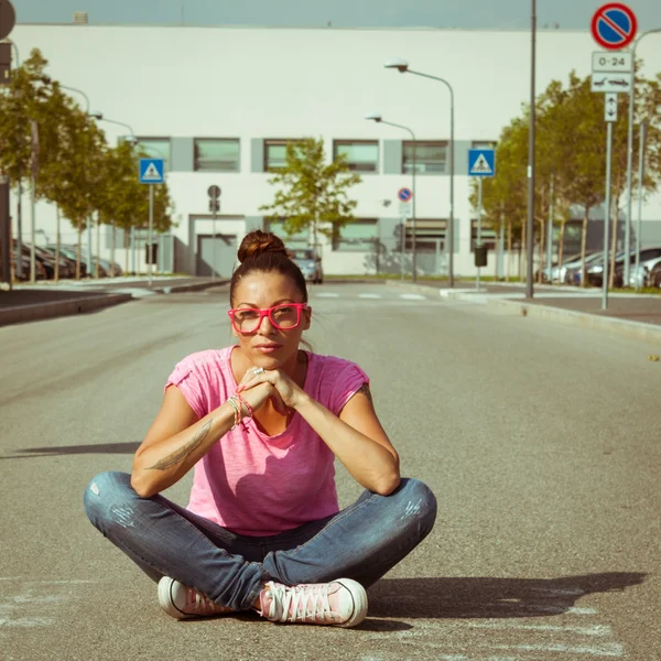 Portrait of a beautiful girl sitting in the street — Stock Photo, Image