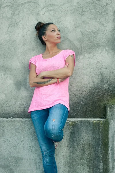 Schönes Mädchen lehnt an Betonmauer — Stockfoto