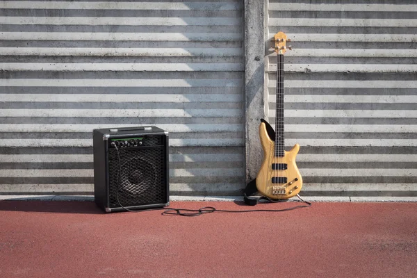 Bajo la guitarra y el amplificador contra una pared — Foto de Stock
