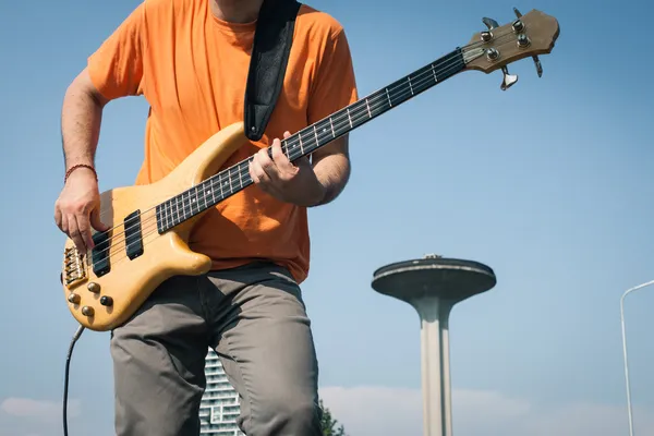 Detail of a young musician playing bass guitar — Stock Photo, Image
