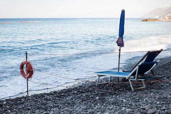 Zamknięty parasol i pusty leżak — Zdjęcie stockowe