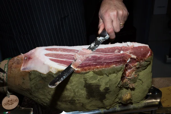 Italian raw ham cut with knife at Golosaria 2013 in Milan, Italy — Stock Photo, Image