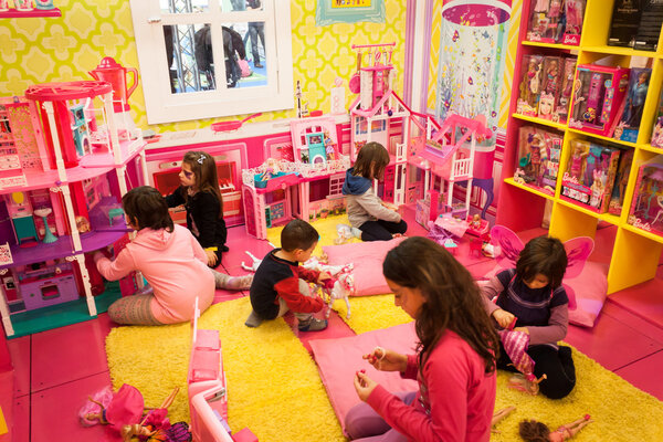 Girls playing inside Barbie's house at G! come giocare in Milan, Italy