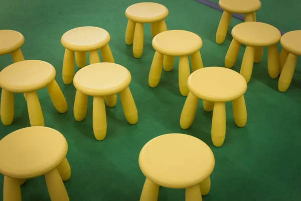 Stools scattered on green floor — Stock Photo, Image