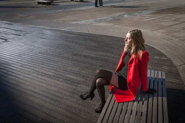 Menina bonita sentada em um banco — Fotografia de Stock