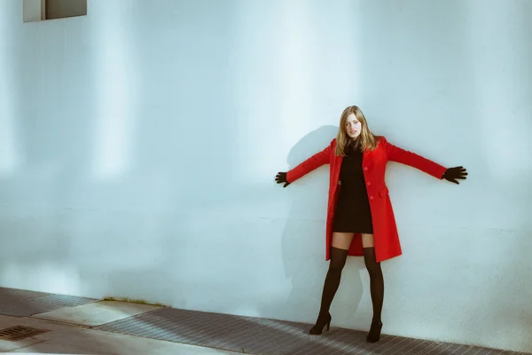 Beautiful girl posing with red coat — Stock Photo, Image