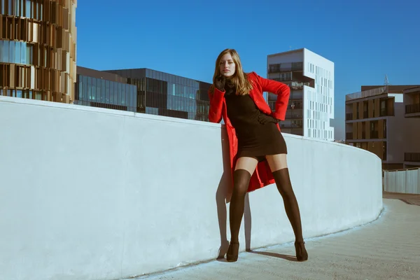 Güzel kız kırmızı paltoyla poz — Stok fotoğraf