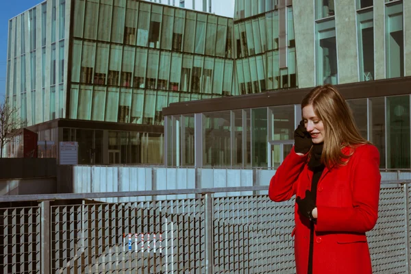 Krásná dívka s červeným kabátem na telefonu — Stock fotografie