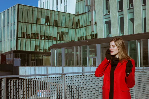 Menina bonita com casaco vermelho falando no telefone — Fotografia de Stock