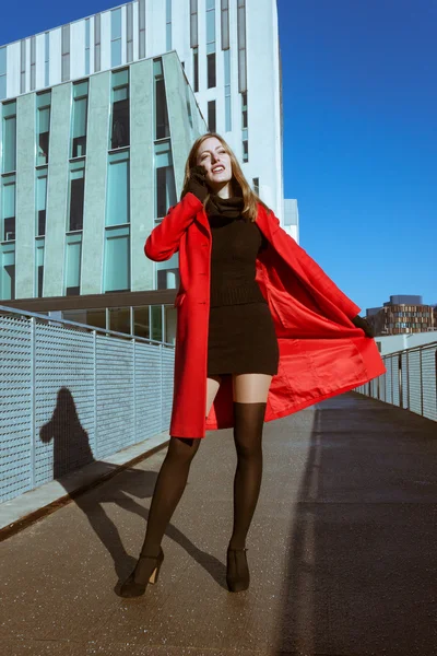 Bella ragazza con cappotto rosso parlare al telefono — Foto Stock