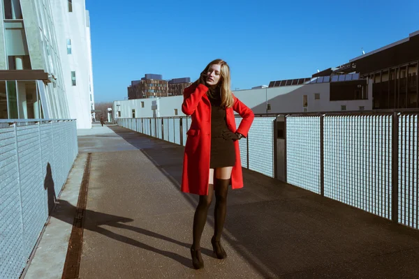 Krásná dívka s červeným kabátem na telefonu — Stock fotografie