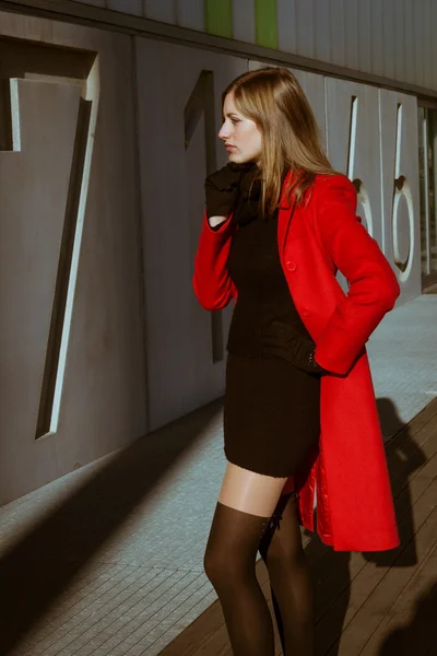 Piękna dziewczyna pozuje z czerwonym płaszczu — Zdjęcie stockowe