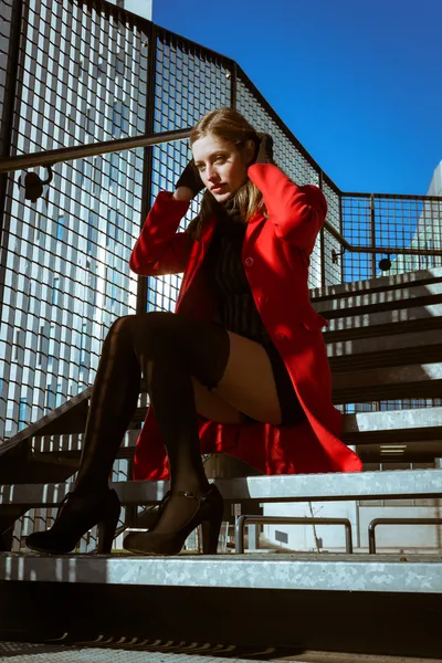 Belle fille posant avec un manteau rouge — Photo