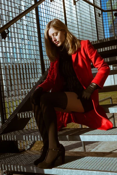 Beautiful girl posing with red coat — Stock Photo, Image