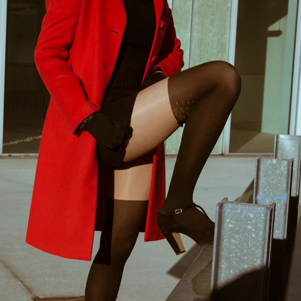 Schönes Mädchen posiert mit rotem Mantel — Stockfoto