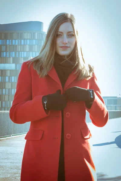 Beautiful girl posing with red coat — Stock Photo, Image