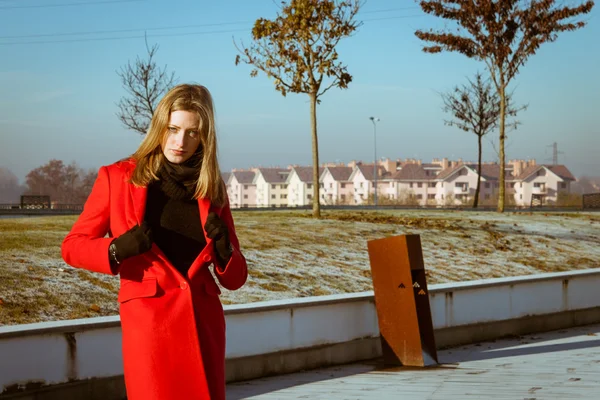 Beautiful girl posing with red coat — Stock Photo, Image