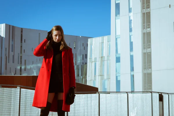Красивая девушка позирует в красном пальто — стоковое фото