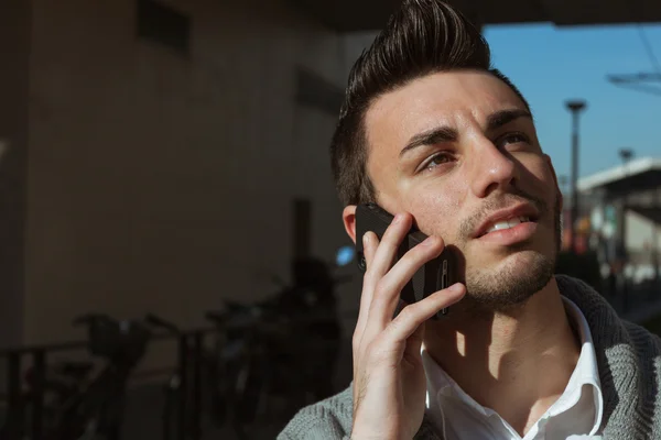 Портрет красивого молодого человека, разговаривающего по телефону — стоковое фото