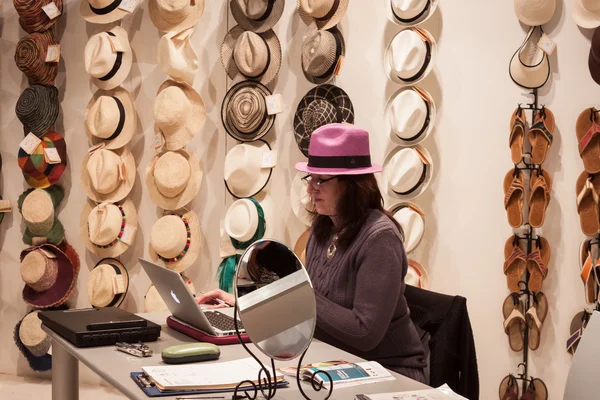 Vrouw verkopen hoeden op homi, huis internationale show in Milaan, Italië — Stockfoto