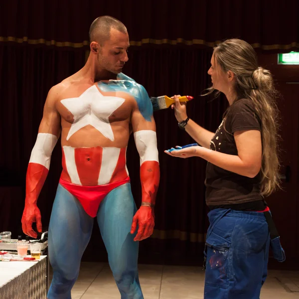 Fisiculturista durante uma sessão de pintura corporal na Convenção Milano Tattoo — Fotografia de Stock