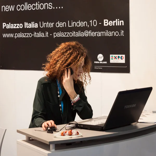 Hermosa anfitriona trabajando en la computadora en Bit 2014, intercambio internacional de turismo en Milán, Italia —  Fotos de Stock