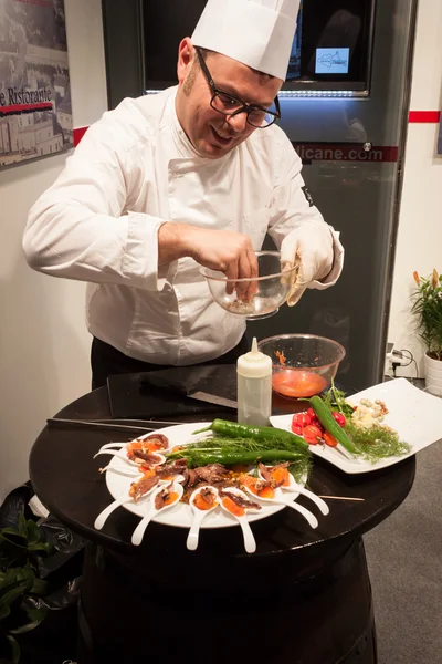 Cook preparing finger food at Bit 2014, international tourism exchange in Milan, Italy — Stock Photo, Image