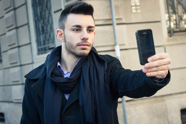 Porträtt av en stilig ung man med en selfie — Stockfoto