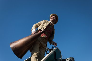 performer roept mensen met behulp van een vintage loudhailer op Milaan clown festival 2014