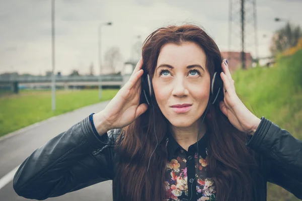 Pretty girl with long hair listening to music — Stock Photo, Image