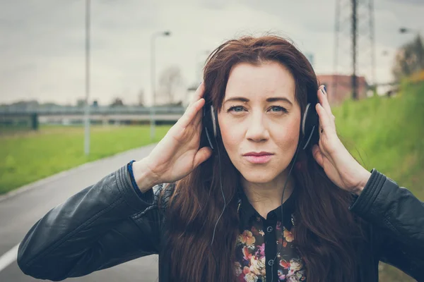 Pretty girl with long hair listening to music — Stock Photo, Image