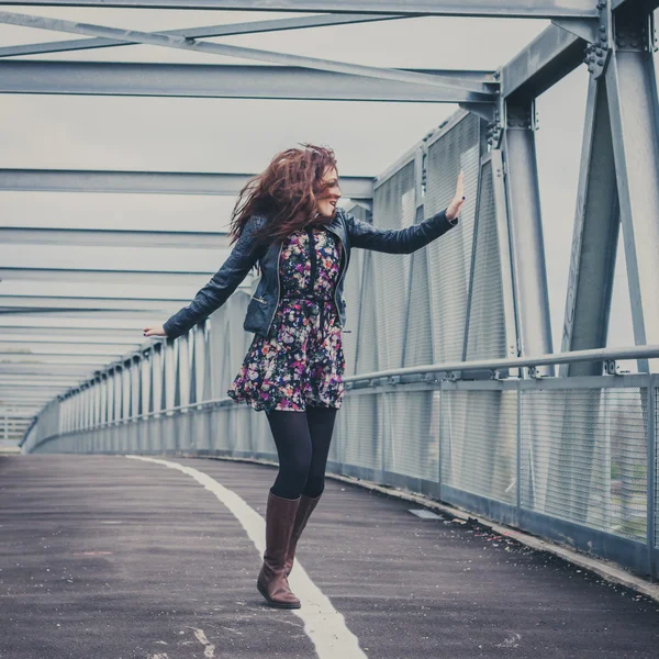 Menina bonita andando feliz em uma ponte — Fotografia de Stock